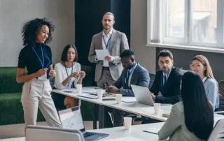 Smiling African female speaker talking to audience during a business conference in office