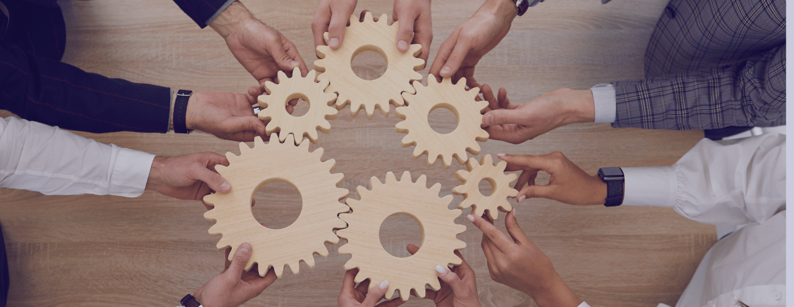 arms in professional attire holding various sized cogwheels